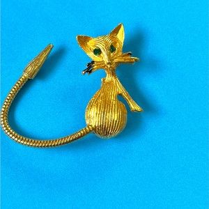 Vintage 1960’s kitty cat pin .Green reinstone eyes, black whiskers, long tail.
